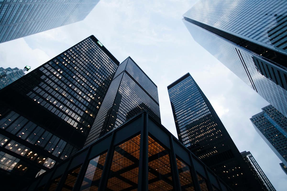 Modern high-rise buildings viewed from below against a cloudy sky
