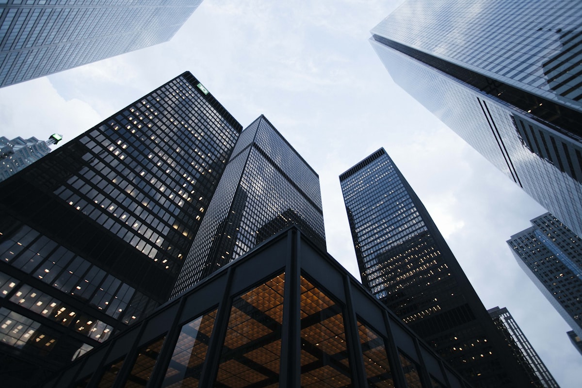 Modern high-rise buildings viewed from below against a cloudy sky